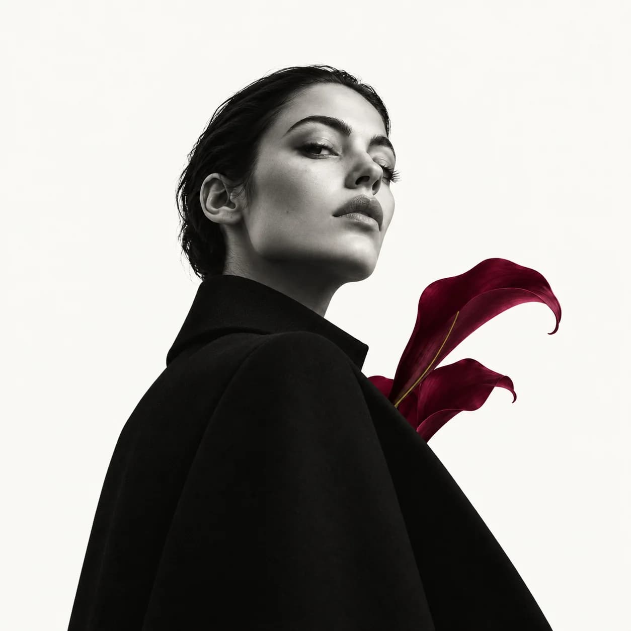 Grayscale editorial portrait of Nina with a burgundy botanical form